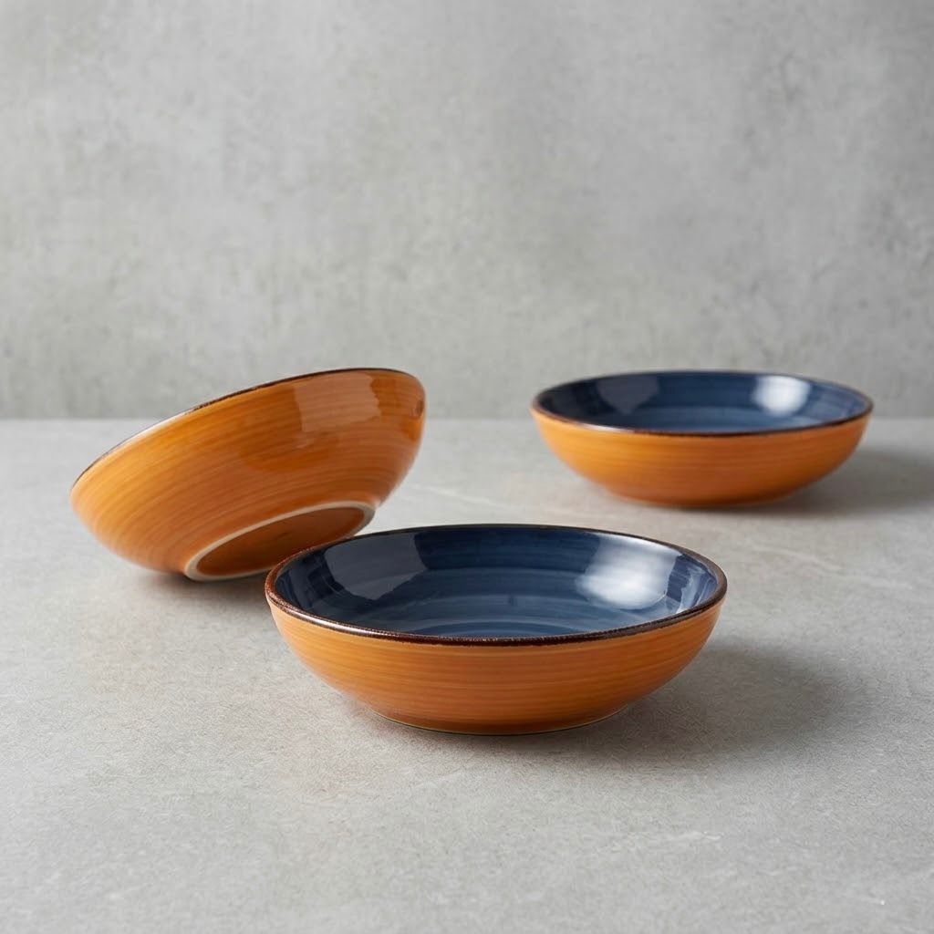 Cuenco de cerámica naranja y blanco con interior azul, rayas y borde marrón