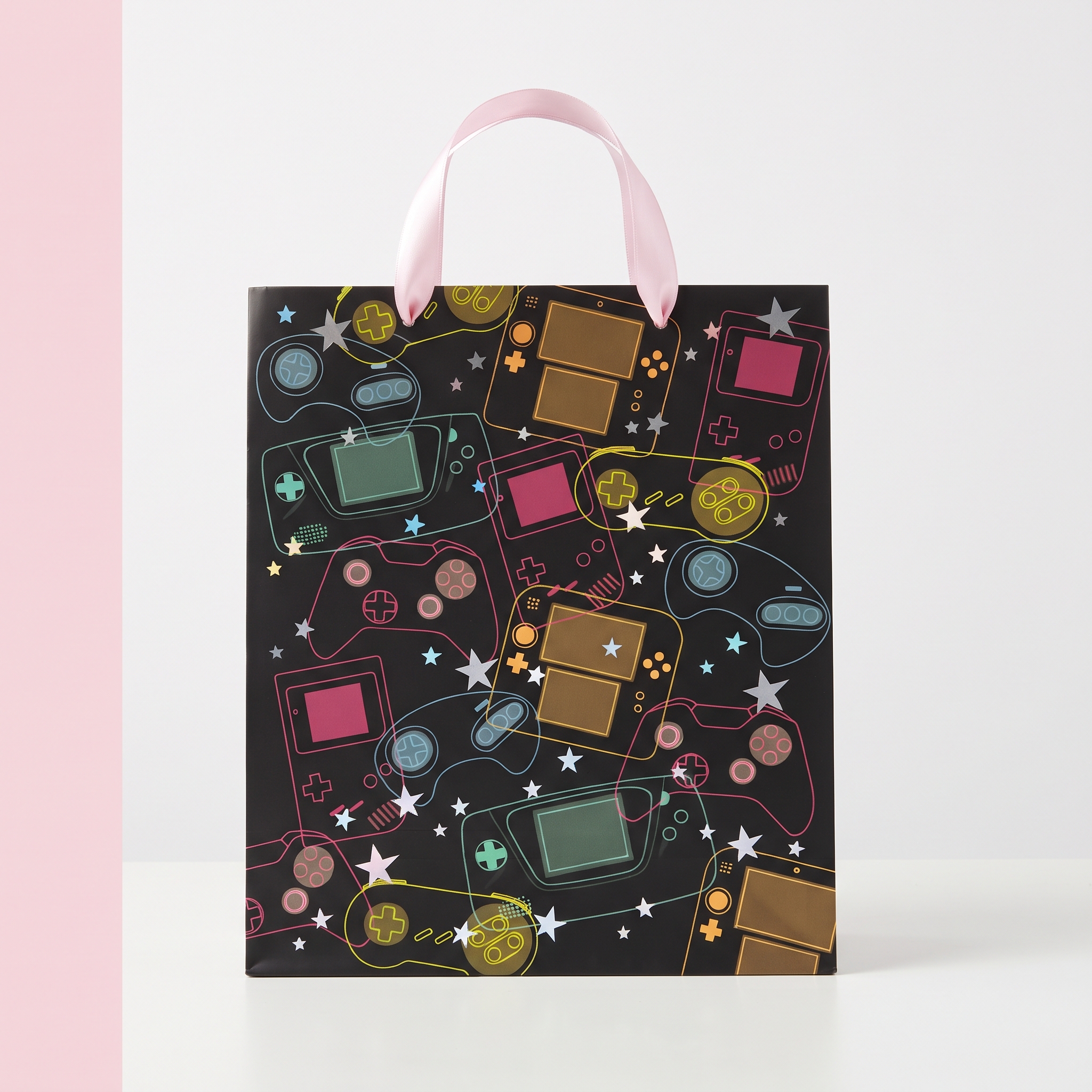 Bolsa de regalo gamer con asas rosas - vista frontal Bolsa de regalo gamer negra con mandos de colores y asas de cinta rosa