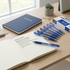 Bolígrafos de gel azul de 0,5 mm sobre escritorio con cuaderno