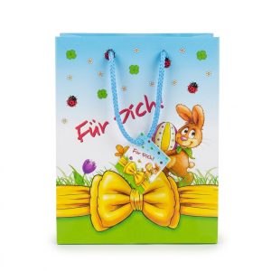 Bolsa de regalo de Pascua con conejo, lazo amarillo impreso y asas azules, vista frontal.