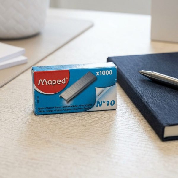 Caja de 1000 grapas Maped número 10 junto a un cuaderno