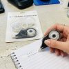 Corrector de cinta en uso sobre un cuaderno