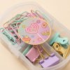 Primer plano de clips y pinzas pastel con detalles dorados y pegatina decorativa de dulces