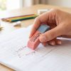 Mano utilizando una goma Maped Duo-Gom en un cuaderno