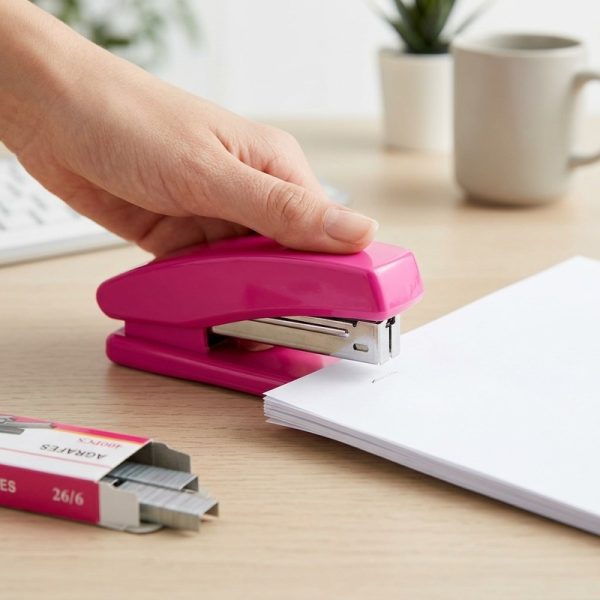 Mano utilizando la grapadora rosa para unir hojas de papel