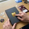 Manos decorando un cuaderno con una pegatina de La Casa de Papel