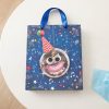 Vista cenital de bolsa de regalo azul con estrellas y notas musicales