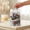 Bolsa de regalo con cámara de fotos presentada en un cumpleaños