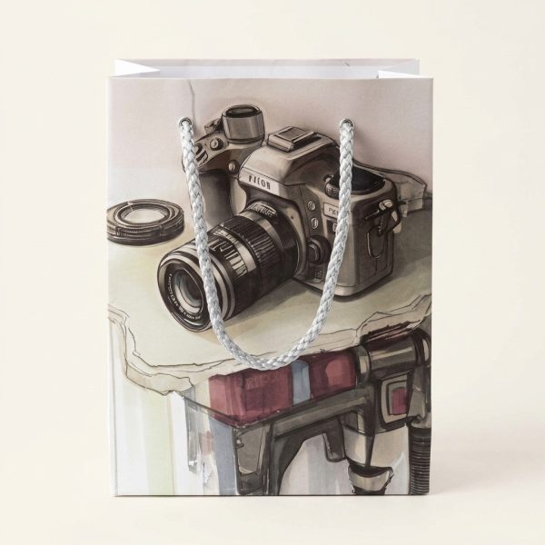 Bolsa de regalo con ilustración de cámara de fotos y asas plateadas, vista frontal