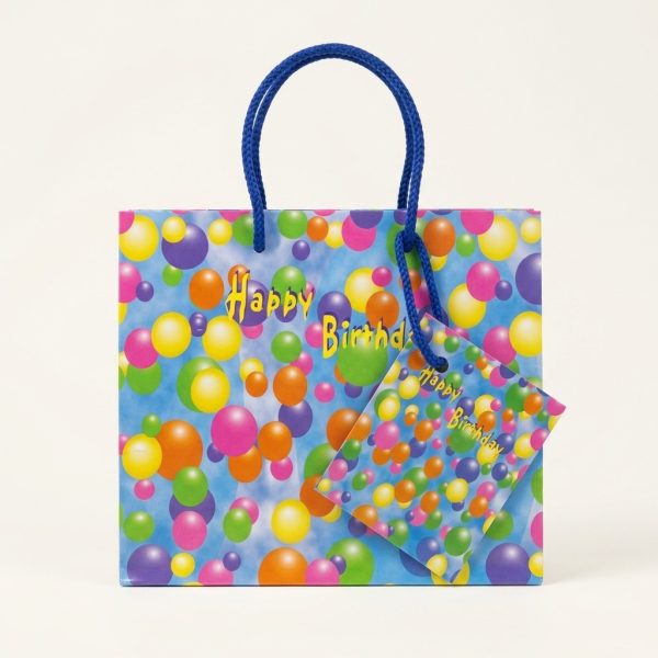 Bolsa de regalo azul con globos, asas y tarjeta, vista frontal