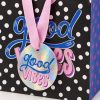 Bolsa Good Vibes - detalle de tarjeta y asas Detalle de la tarjeta redonda holográfica Good Vibes y las asas de cinta rosa