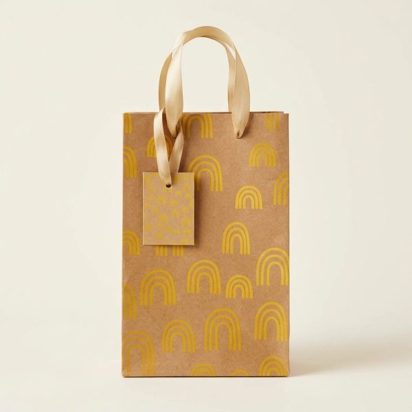 Bolsa de regalo kraft con arcoíris amarillos y asas doradas, vista frontal