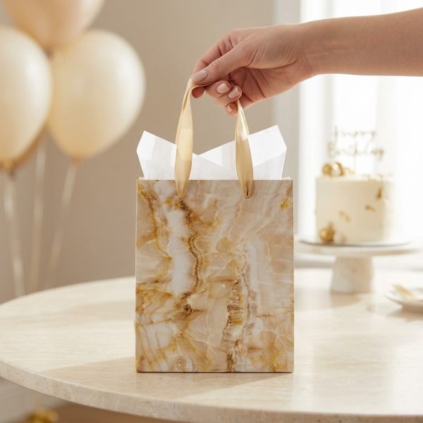 Bolsa de regalo efecto mármol dorado en uso durante un cumpleaños