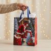Bolsa de regalo navideña con Papá Noel y muñeco de nieve preparada para entregar, con papel de seda decorativo no incluido.
