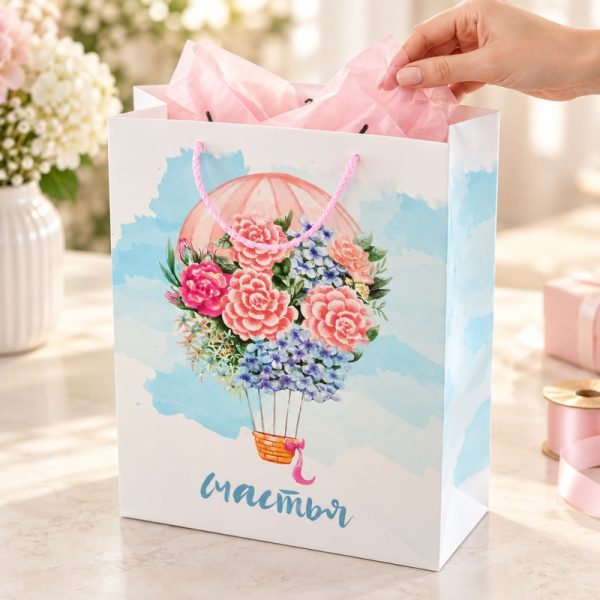 Bolsa de regalo con globo floral y asas rosas, bolsa en uso con papel de seda decorativo