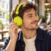 Auriculares verdes con cable en uso Chico usando auriculares de diadema verde lima con cable