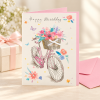 Tarjeta de cumpleaños Bicicleta con flores junto a un regalo Tarjeta de cumpleaños Bicicleta con flores junto a un regalo