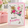 Tarjeta Happy Birthday de copa floral presentada junto a un regalo