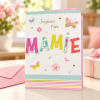 Tarjeta para abuela Joyeuse Fête Mamie con mariposas en uso junto a un regalo | Shumy Tarjeta para abuela Joyeuse Fête Mamie con mariposas en uso junto a un regalo