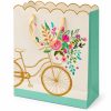 Bolsa de regalo con bicicleta dorada, flores y borde ondulado — vista lateral